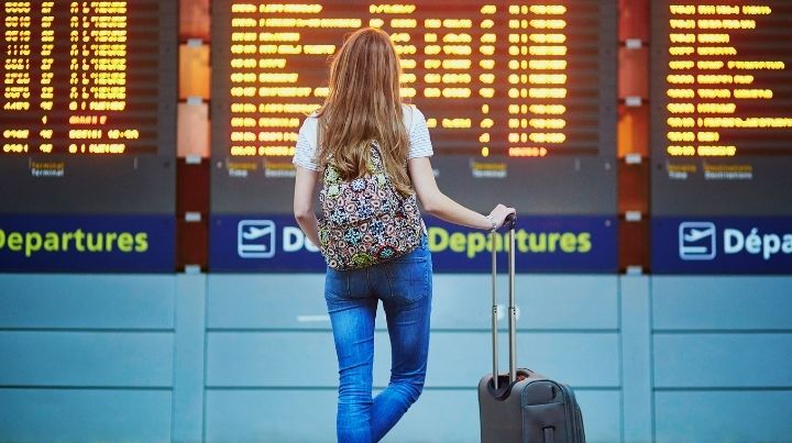 Woman at airport with backpack and carry on luggage