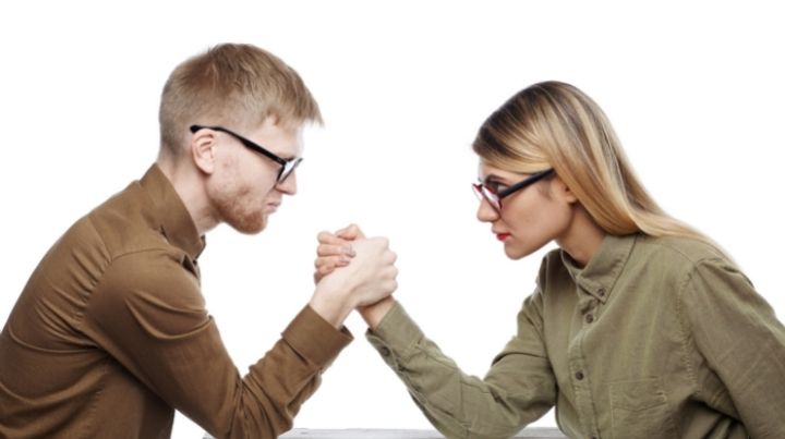 A man and woman arm wrestling