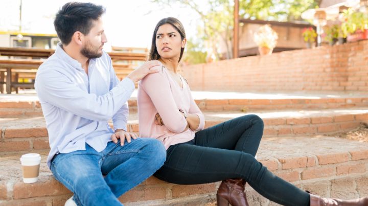 Man talking with upset woman on park bench