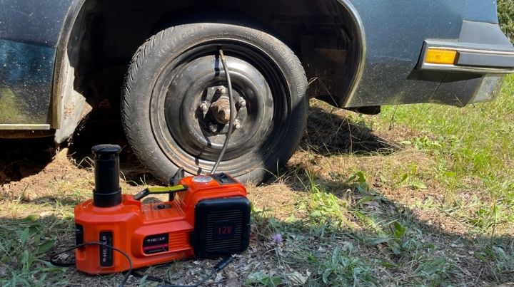 A combo jack and tire inflator hooked up to a car