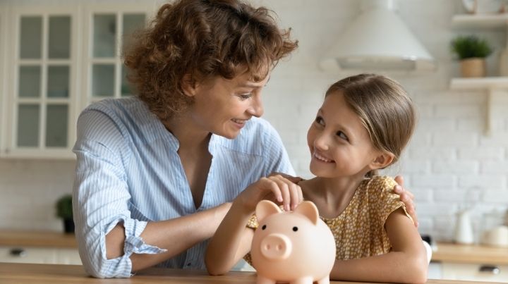 mom, daughter, and piggy bank
