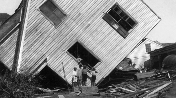 Children in front of a house flipped on its side