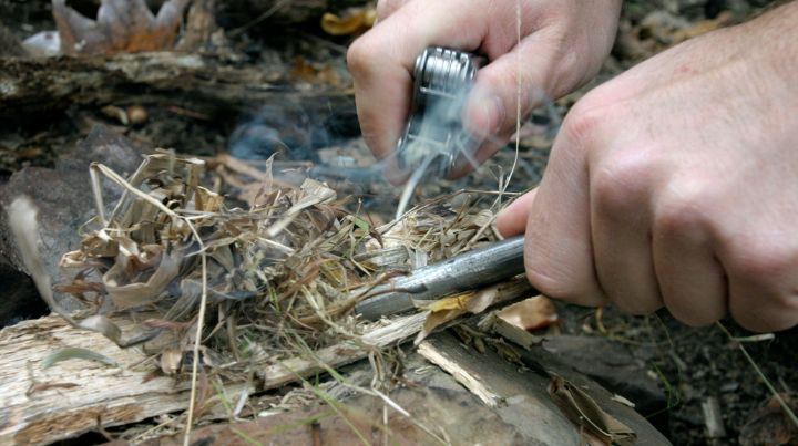 Person starting a camp fire