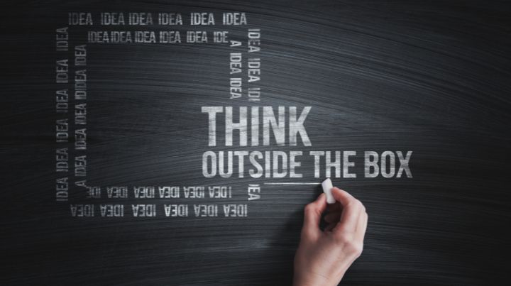 Writign on chalkboard that sates "Think Outside of the Box"