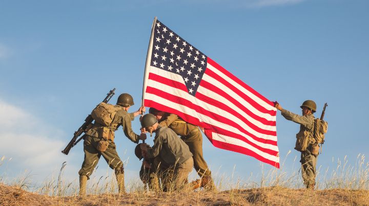 Soldiers using teamwork to raise a flag