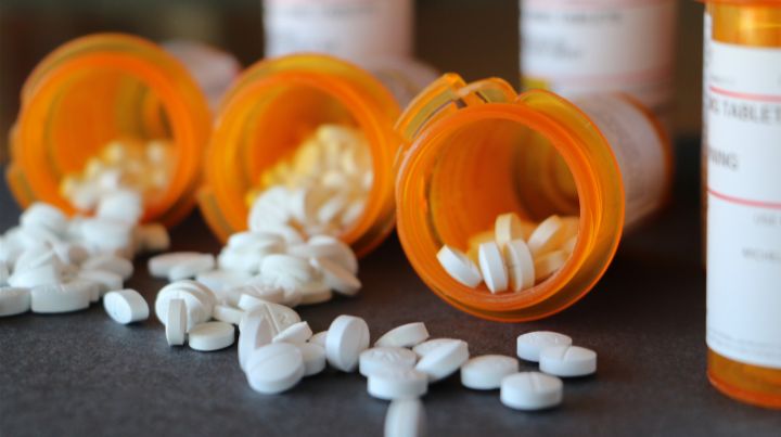 Bottles of prescription pills spilled onto a table. 