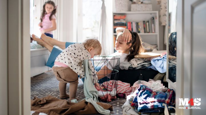 A toddler picking up clothes