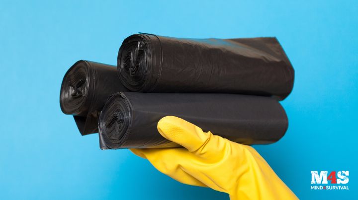 A woman holding empty trash bags. 